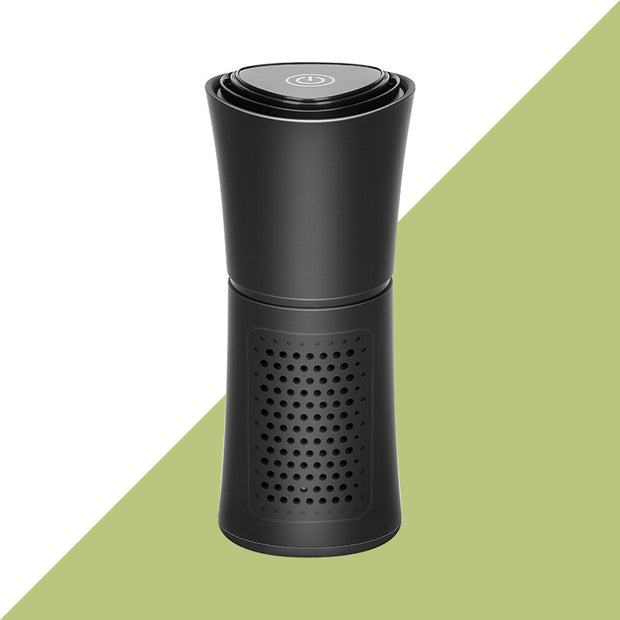 Black portable air purifier with power button on top and perforated vent design