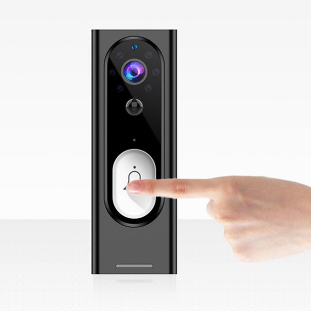 Hand pressing the button on a modern black smart video doorbell with camera