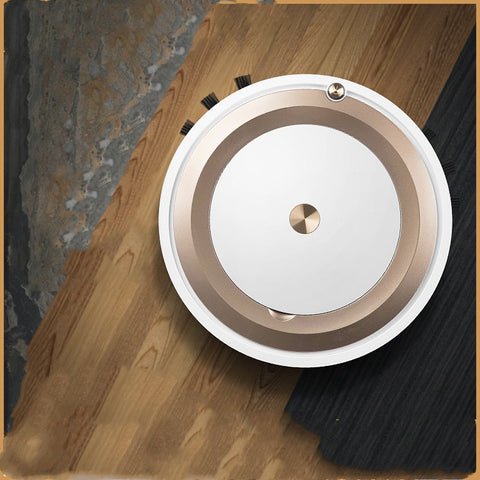 Top view of white and gold robotic vacuum cleaner on mixed hardwood and carpet floor