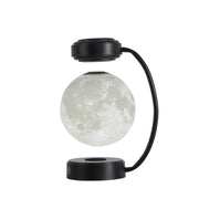 Levitating moon lamp with black curved stand and round base against white background