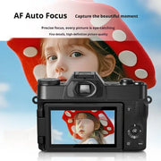 Mirrorless digital camera with auto-focus capturing a girl in a red polka dot hat against a blue sky