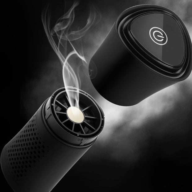 Black portable air purifier with smoke and power button on cap, isolated on dark background