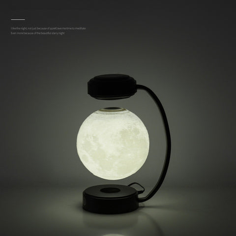 Modern levitating moon lamp with black stand glowing softly in dark room