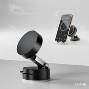 Black foldable car phone holder with magnetic mount and adjustable arm on a gray surface