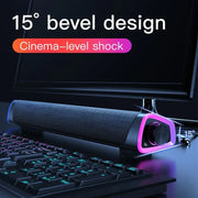 15-degree bevel designed black desktop speaker with neon purple light ring next to a computer monitor and keyboard
