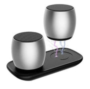Silver wireless Bluetooth speakers with one levitating above charging base emitting purple and blue lightning effect