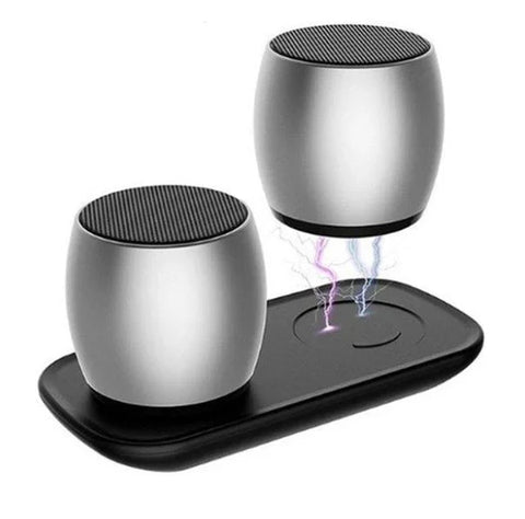 Silver wireless Bluetooth speakers with one levitating above charging base emitting purple and blue lightning effect
