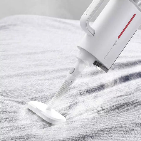 White Deerma ZQ610 steam cleaner in use, emitting steam on a fabric surface, handheld design