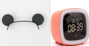 Digital desk clock with thermostat in coral casing showing 21.5°C and 08:39 PM next to black mouse ear headband on white background