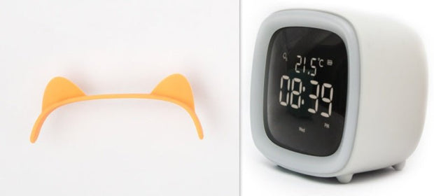 White digital desk clock with thermostat showing 21.5°C and time 08:39 PM, next to yellow cat ear-shaped accessory
