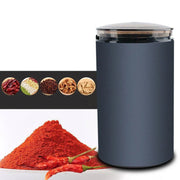 Modern electric spice grinder with dried chili powder and red chili peppers, spices in bowls