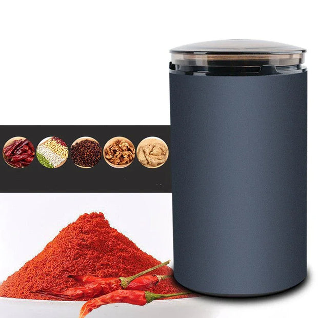 Modern electric spice grinder with dried chili powder and red chili peppers, spices in bowls