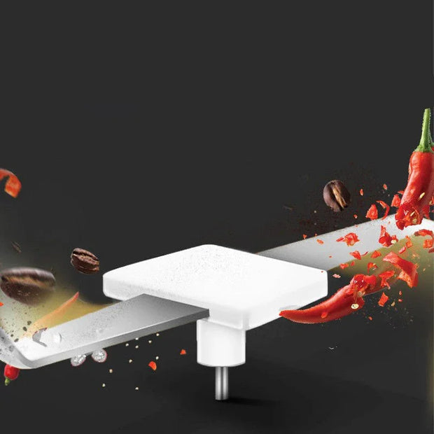 Close-up of electric grinder blade with chili peppers and coffee beans on black background