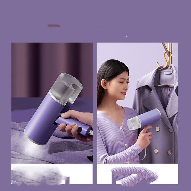 Portable foldable handheld garment steamer in lavender color steaming a purple coat and fabric