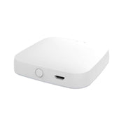 White smart home hub device with round button and USB port on side