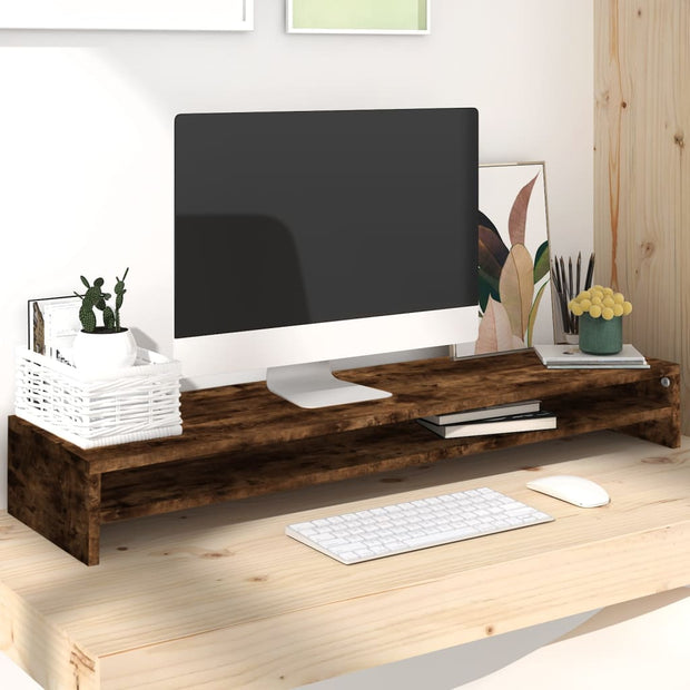 Smoked oak wooden monitor stand on light desk with computer, keyboard, mouse, and decorative plants