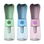 Portable pet water bottles in green, blue, and pink with paw print buttons and built-in drinking bowls
