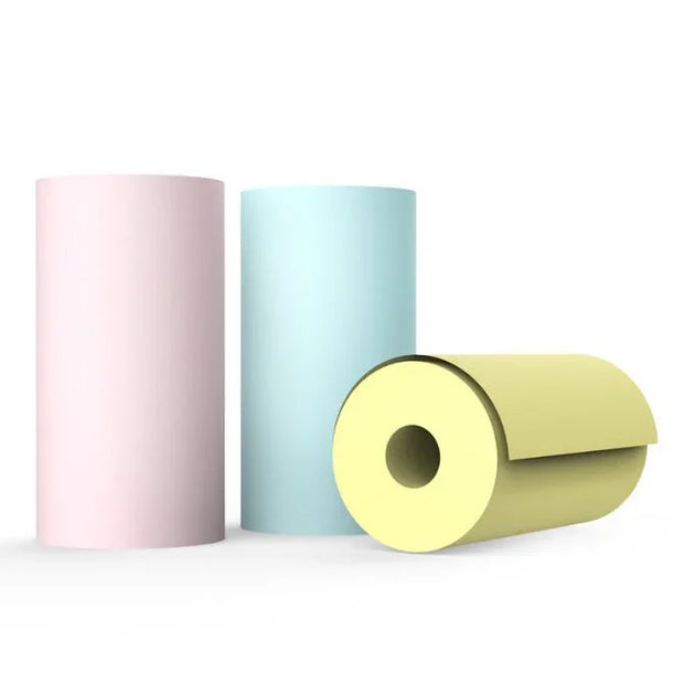 Three thermal paper rolls in pink, blue, and yellow used for portable Bluetooth printers