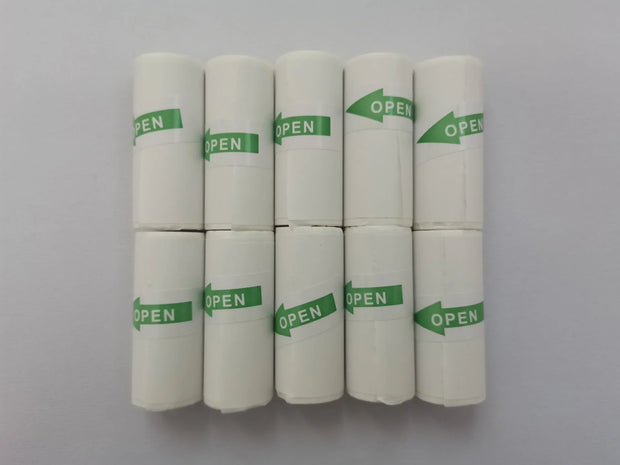 Eight rolls of white thermal paper with green 'OPEN' labels, arranged in two rows on a white surface