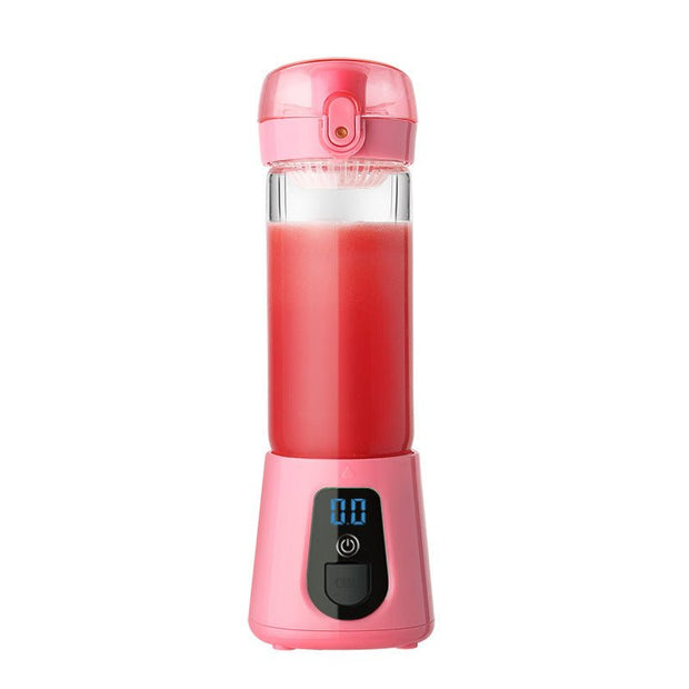 Pink portable blender juicer with digital display and red juice inside on white background