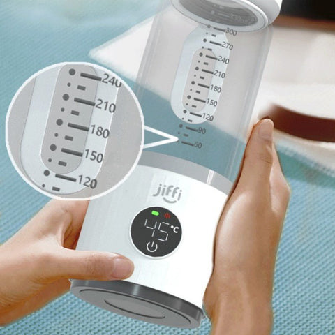 Hands holding Jiffi portable milk temperature regulator with digital display showing 45°C and measurement markers