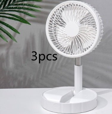 Portable white telescopic folding fan on white surface with green plant leaves in background