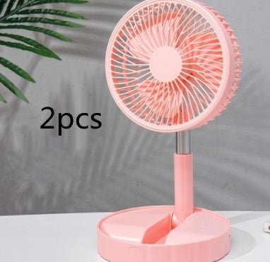 Pink portable telescopic folding fan on white surface with plant shadow backdrop