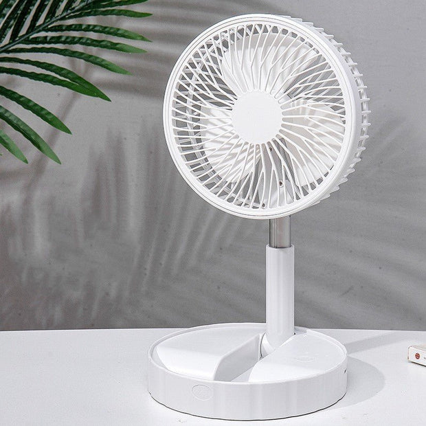 White portable telescopic folding desk fan on a white surface with green plant shadows