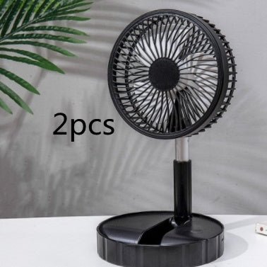Black portable telescopic folding fan on desk with green plant in background