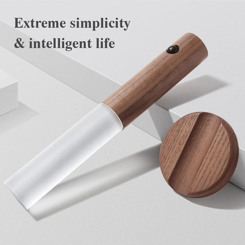 Minimalist wall sensor light with wooden handle and frosted white diffuser on white surface