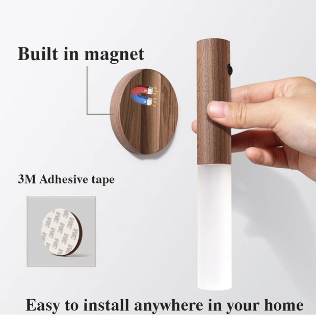 Hand holding wooden sensor wall light with built-in magnet and 3M adhesive tape mount