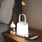 Modern white smart bedside lamp with wireless charging on wooden nightstand beside sofa and baby bottle