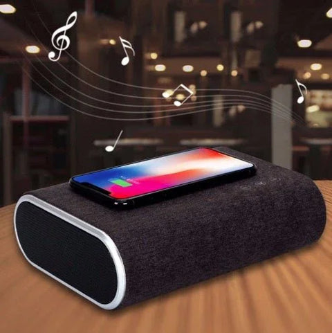 Wireless charger speaker with fabric finish on wooden table playing music for smartphone