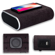 Multi-angle view of wireless charger speaker with black fabric finish, smartphone charging on top, USB and audio ports